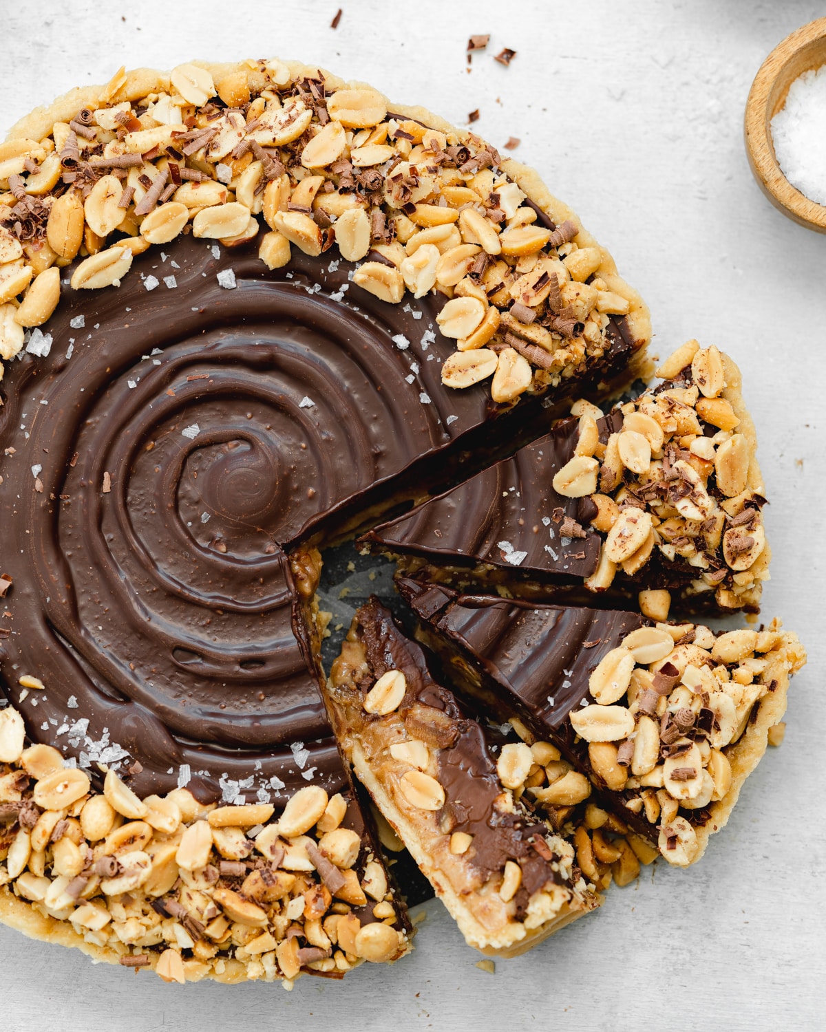 chocolate tart with peanut butter center and roasted peanuts on top.