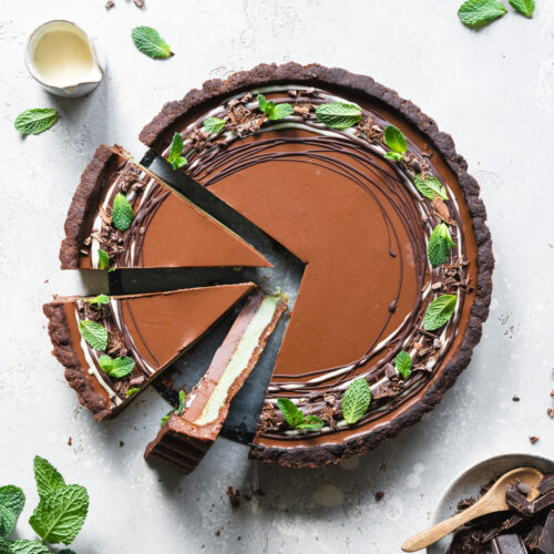 flatlay of sliced mint chocolate tart with fresh mint leaves.