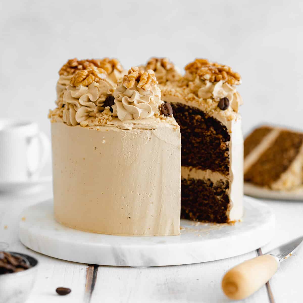 vegan coffee cake with swiss meringue buttercream on marble cake stand.