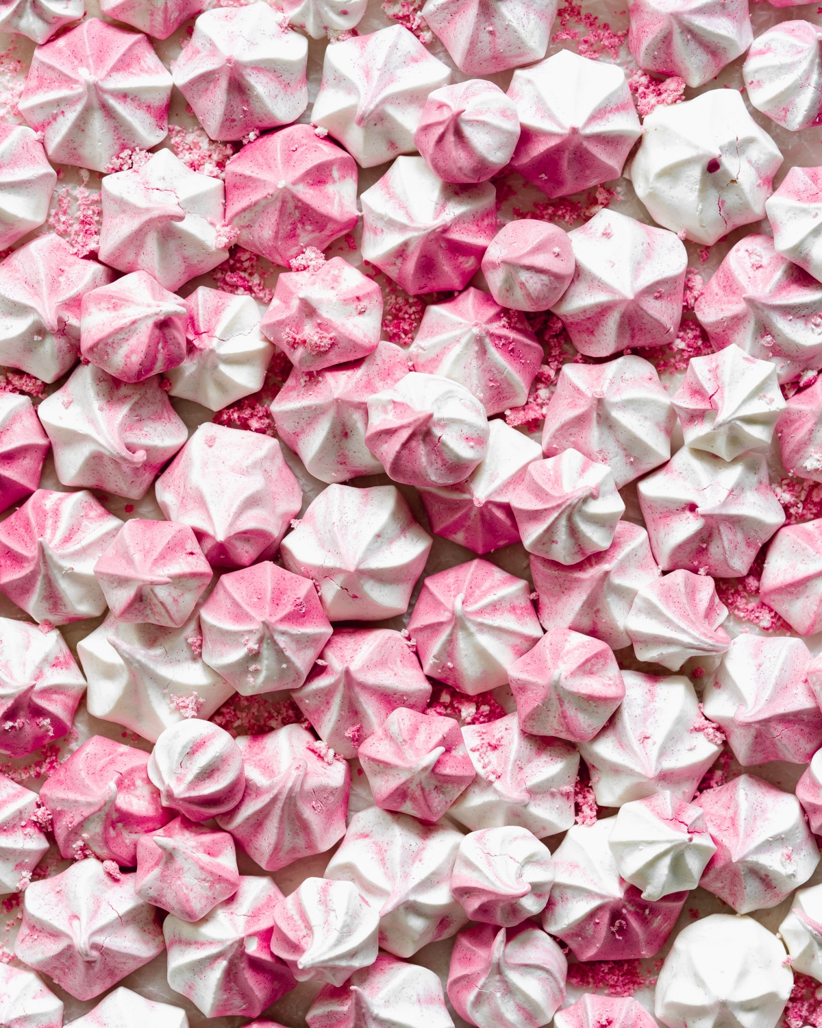close up of white and pink aquafaba meringue kisses.