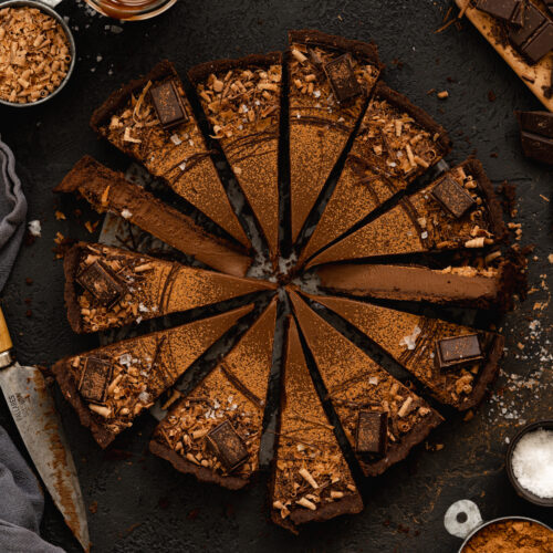 chocolate tart sliced on a dark background.