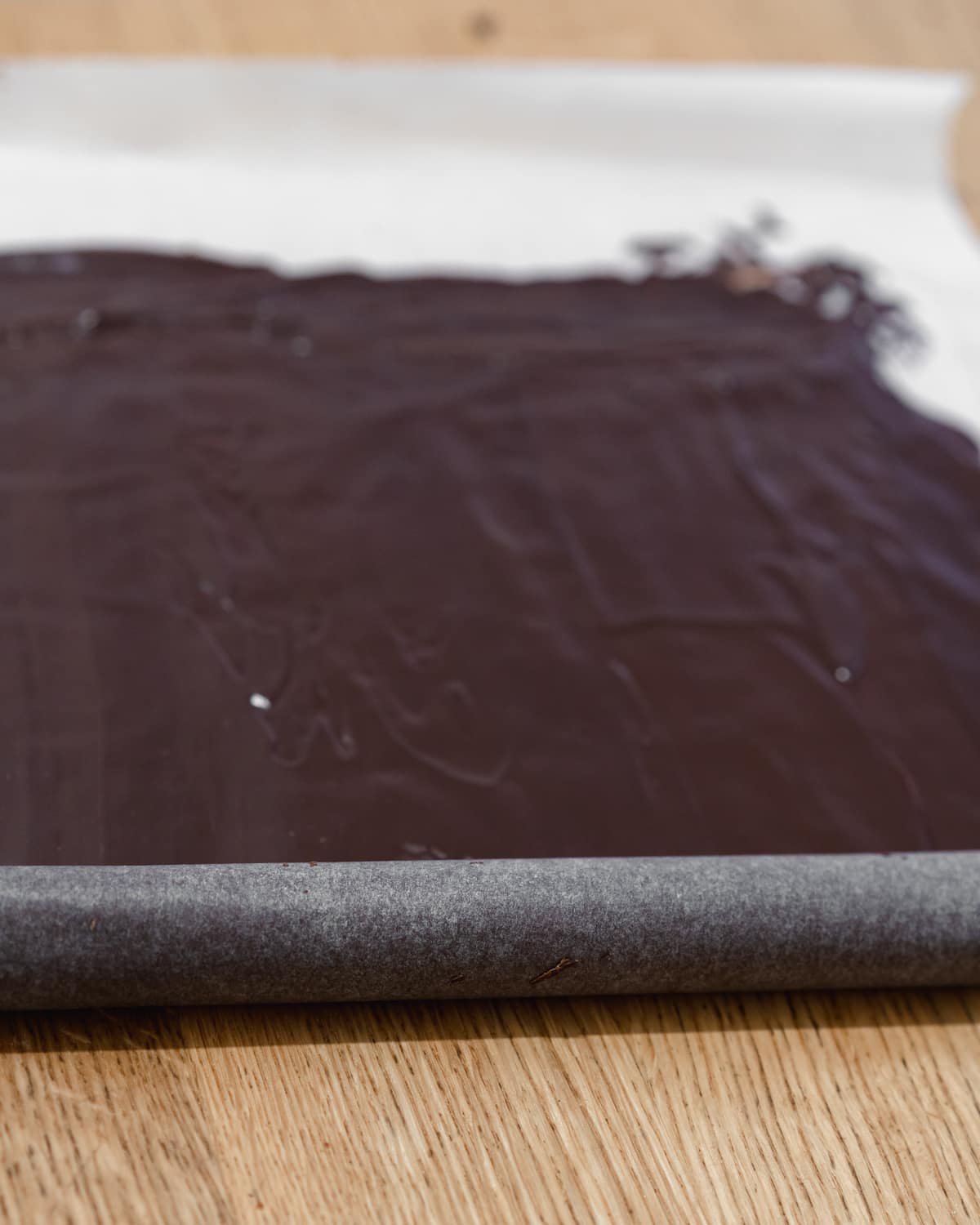 rolling up melted chocolate in parchment to make chocolate bark.