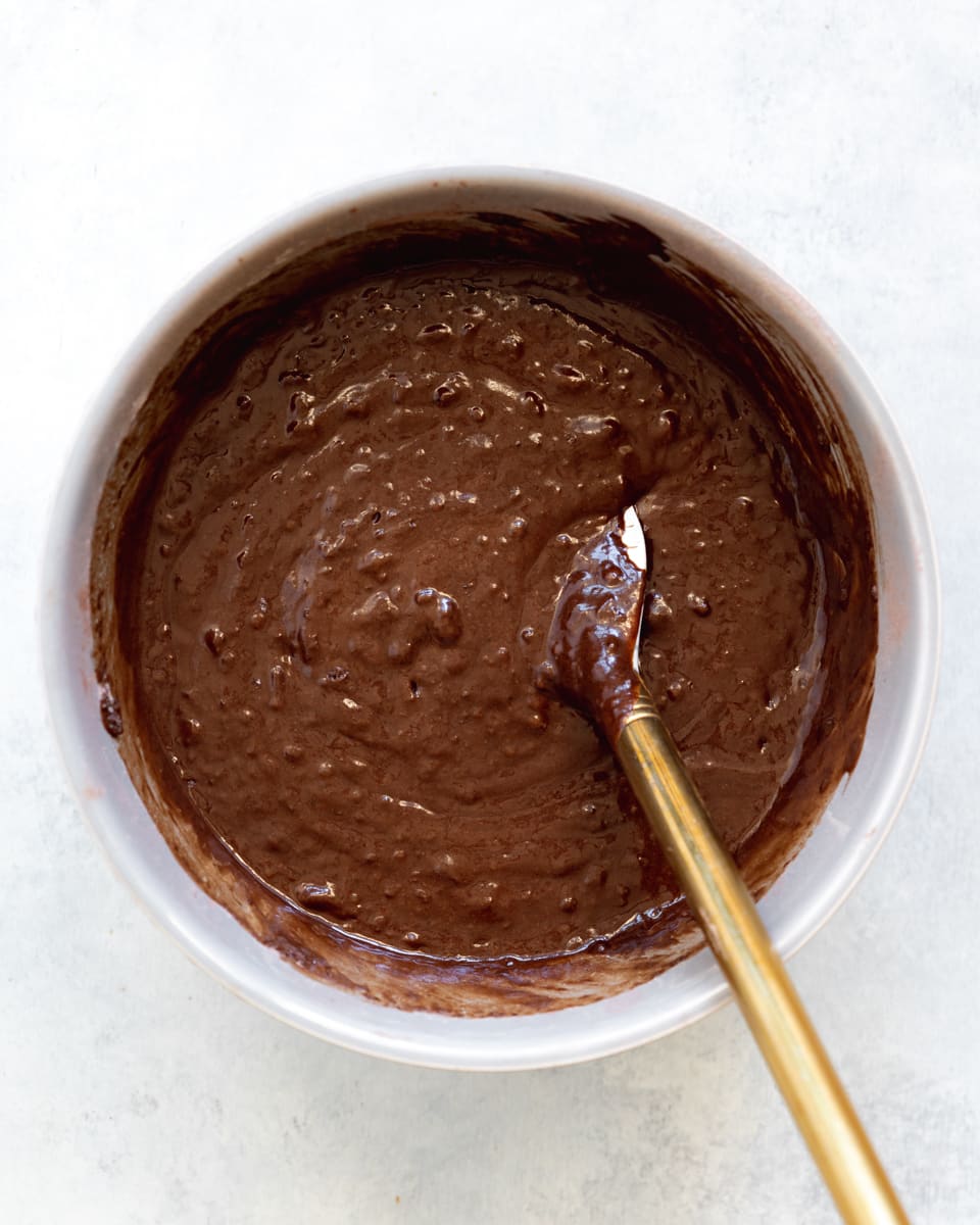 vegan chocolate cake batter in a bowl with a spatula.