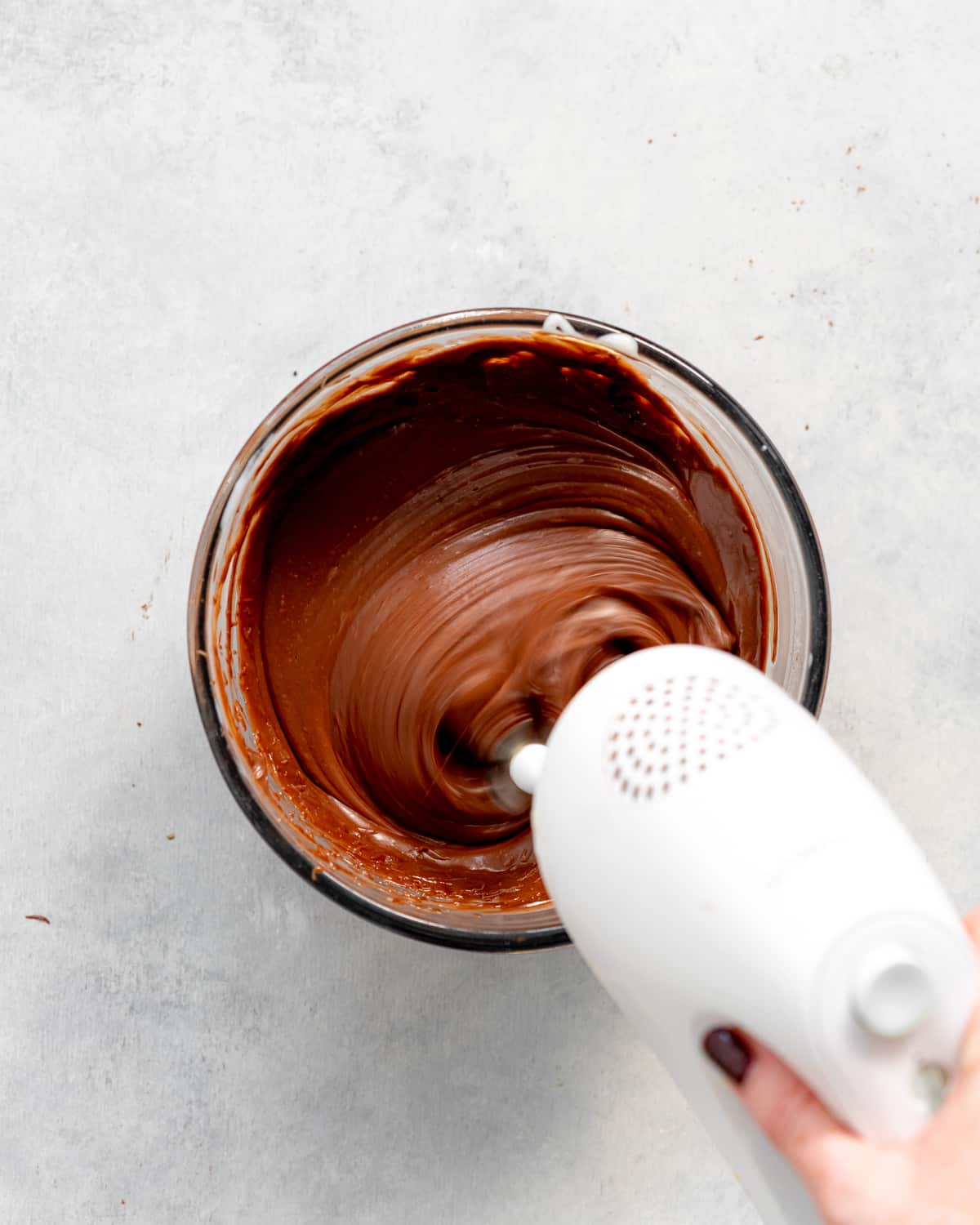 whisking chocolate cremeux with an electric whisk.